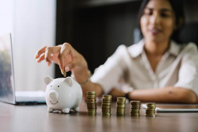 woman-putting-coins-in-piggy-bank.jpg