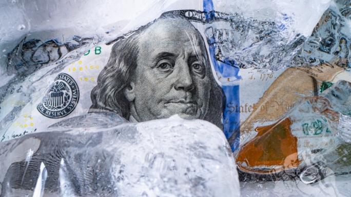 An image of American currency with ice cubes