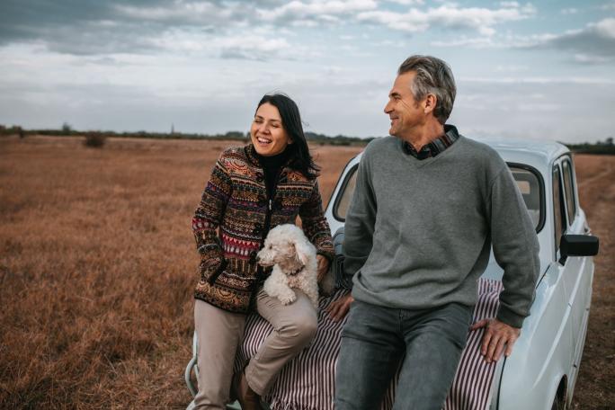 A couple with dog looking over fields