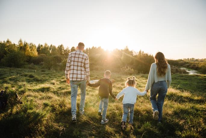Family of four heading into sunset