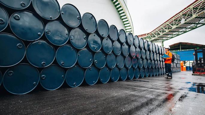 Man doing inventory of oil barrels
