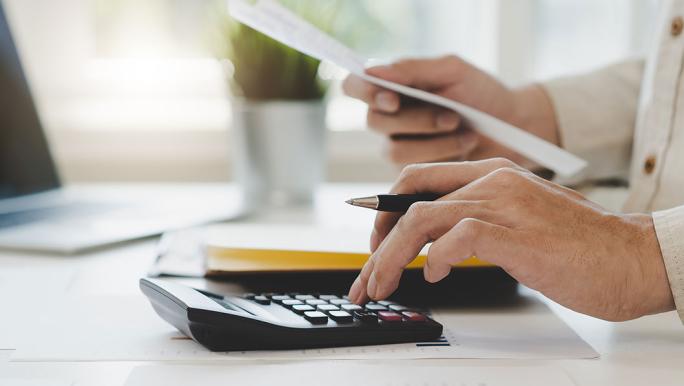 Man with pen using calculator