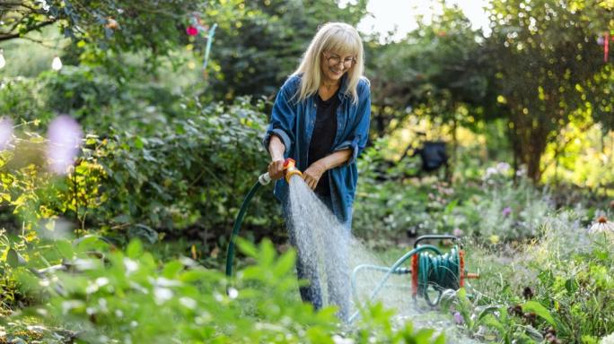 Mature woman watering plants