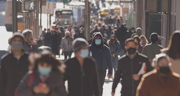 People wearing surgical masks in crowded street