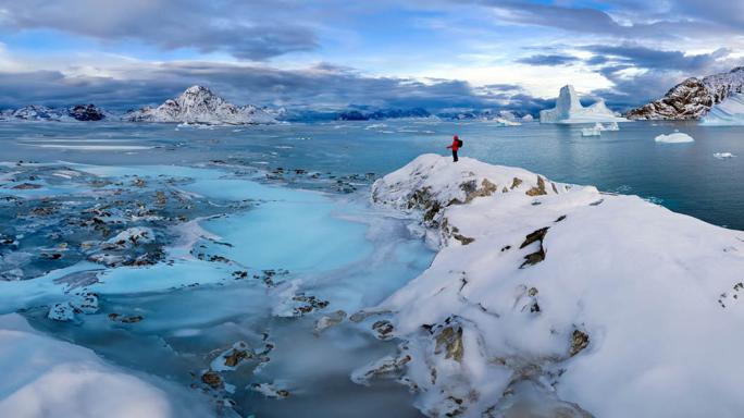 Partly frozen sea and icebergs in Hurry Inlet in Scoresbysund on the east coast of Greenland
