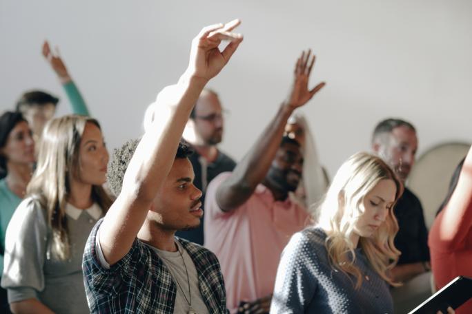 People with their hands in the air to answer questions