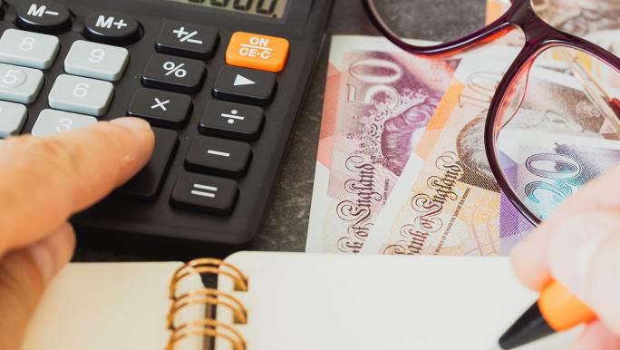 Cash, calculator, glasses, notepad and pen