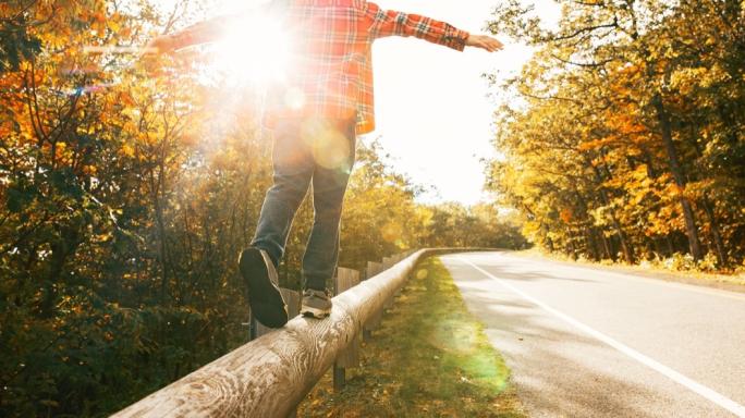 Boy walking along the road fence
