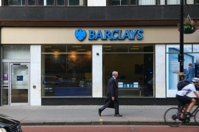 business man walking past a barclays bank branch