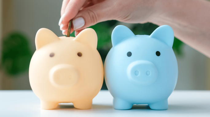 Yellow and blue piggy banks with a female hand