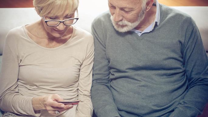 A couple looking at their finances on a mobile phone