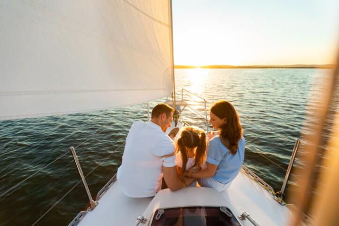 family sat on a yacht at sunset