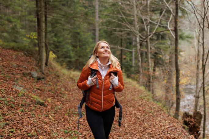 female hiker in the forest during autumn