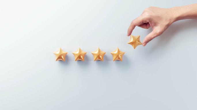 Hand picking a star from five gold stars