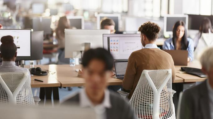 full open plan office of workers on computers