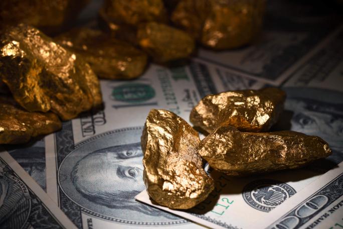 gold nuggets on dollar bills