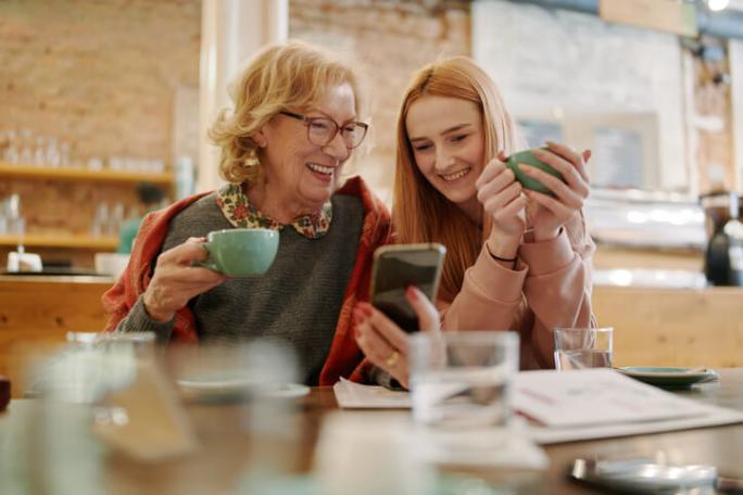 grandmother smiling with granddaughter in a cafe