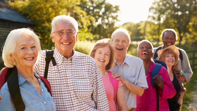 group of senior people smiling outside on a walk