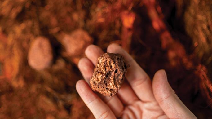 hand holding a piece of copper