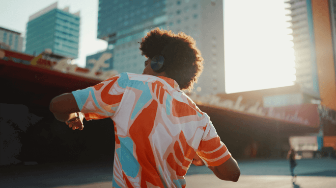 Man dancing in the city with headphones