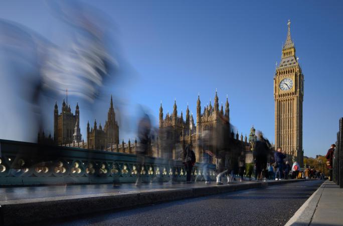 pedestrians passing big ben and houses of parliament