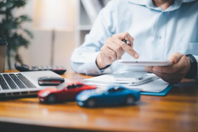 person sat behind office desk with laptop and toy cars