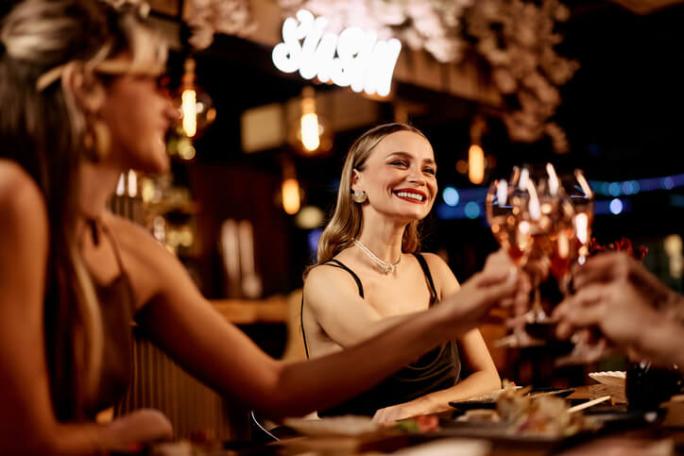 smiling women celebrating together with drinks