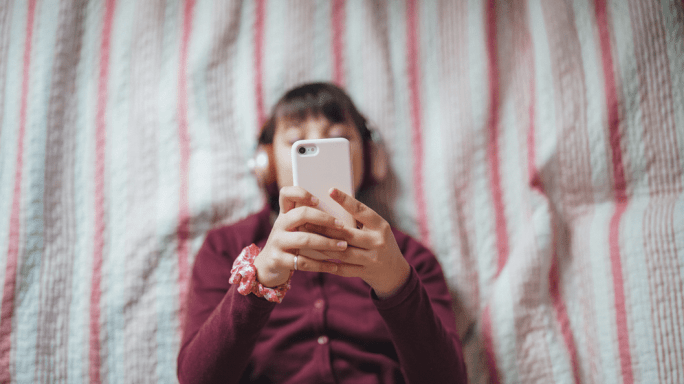 Young girl listening to music in bed