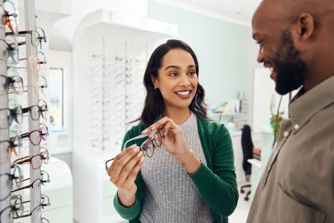 two people trying on glasses at an opticians