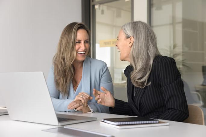 two women laughing in the office