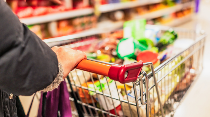 Woman pushing a supermarket trolley