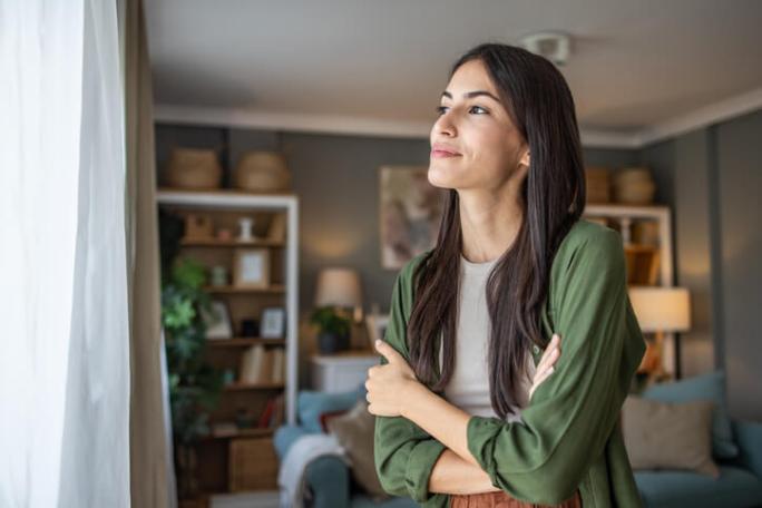 woman looking out the window at home