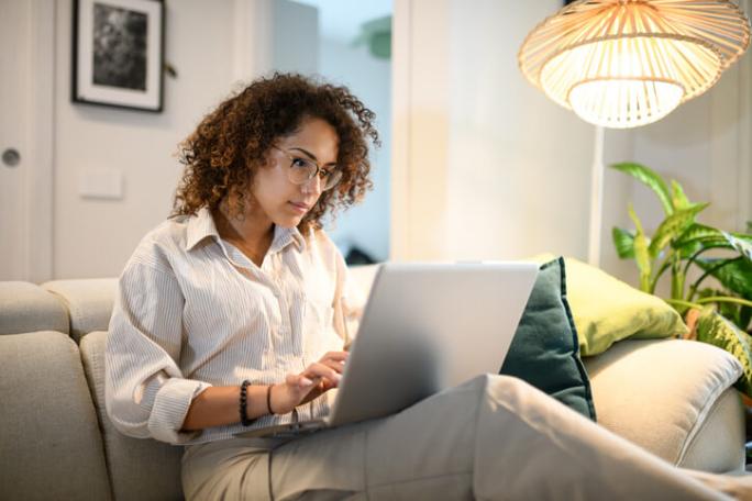 woman using laptop on sofa