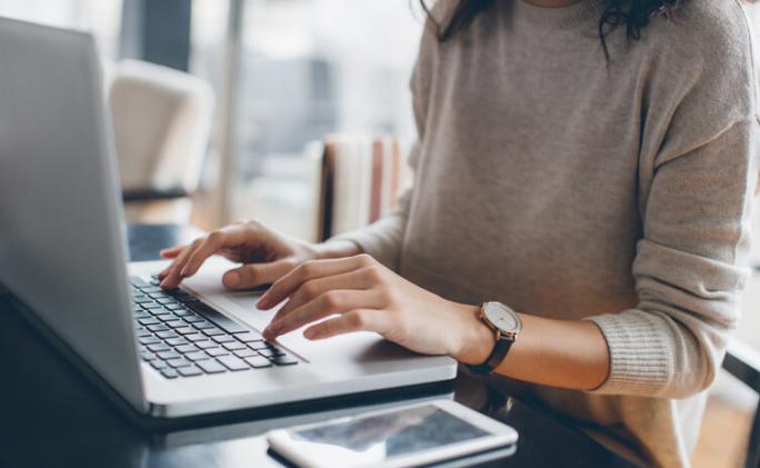 woman wearing a watch using laptop at home