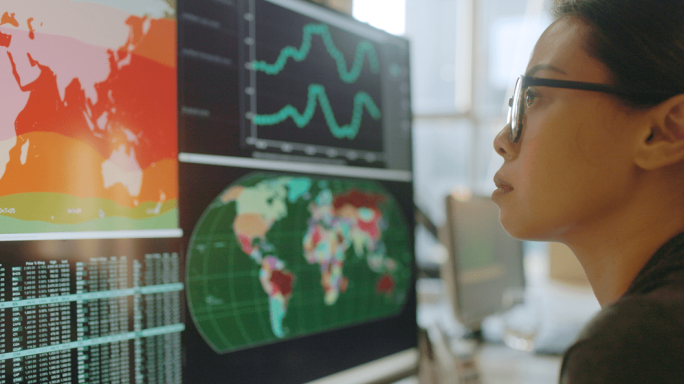 Woman looking at world maps and graphs