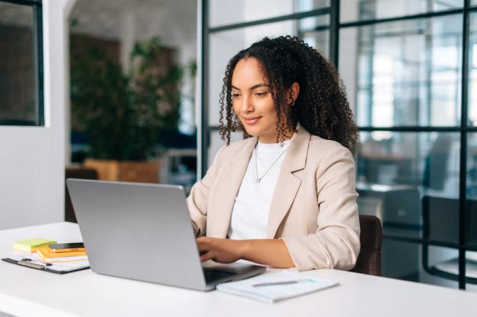 young woman using laptop in office environment