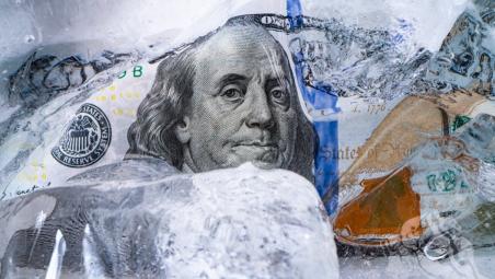 An image of American currency with ice cubes