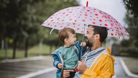 Man and child holding umbrella