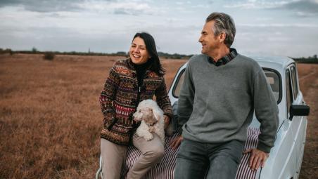 A couple with dog looking over fields