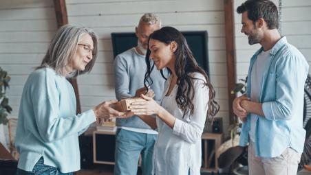 Happy senior parents meeting young couple inside the house