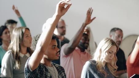 People with their hands in the air to answer questions