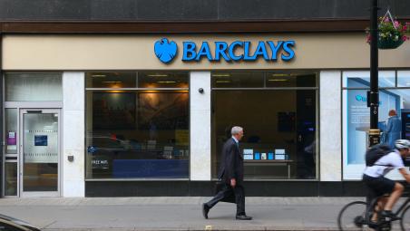 business man walking past a barclays bank branch