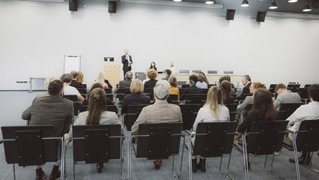 room full of business people watching a presenter