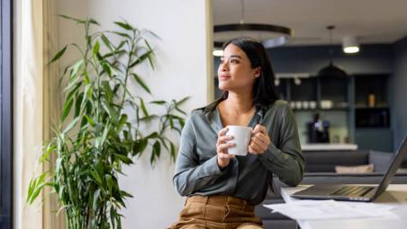 businesswoman in the office holding a mug and thinking