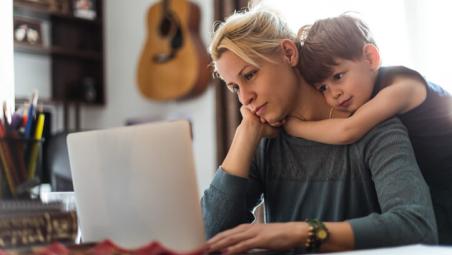 child hugging mum as she works