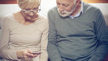A couple looking at their finances on a mobile phone