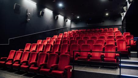 empty cinema screen with red seats