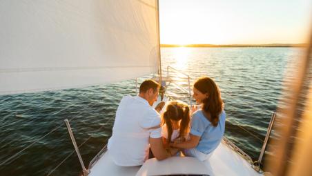 family sat on a yacht at sunset