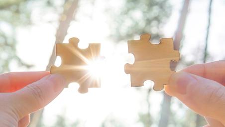 Two hands holding jigsaw pieces