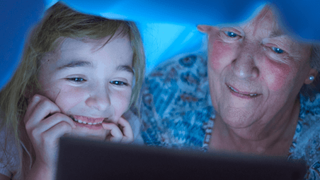 Grandma and granddaughter reading tablet